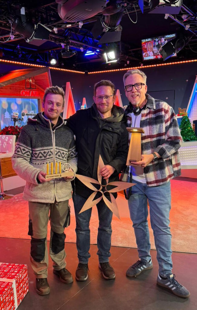 Ungefähr zur Halbzeit des Weihnachtswunders hatten Matthias Spehr (l.), Obermeister der Tischler-Innung Essen, und Jens Südmeier von Tischler NRW (Mitte) die Möglichkeit, am gläsernen WDR 2-Studio auf dem Essener Burgplatz die Spenden-Produkte kurz vorzustellen und den bis dato gesammelten Spenden-Zwischenstand durchzugeben. Foto: Tischler NRW